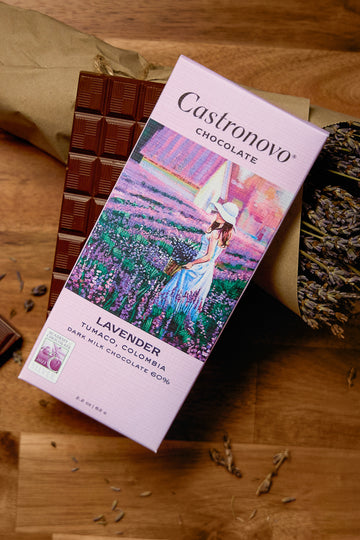 A chocolate bar packaging with an image of a woman in a field of lavender, alongside pieces of dark milk chocolate.